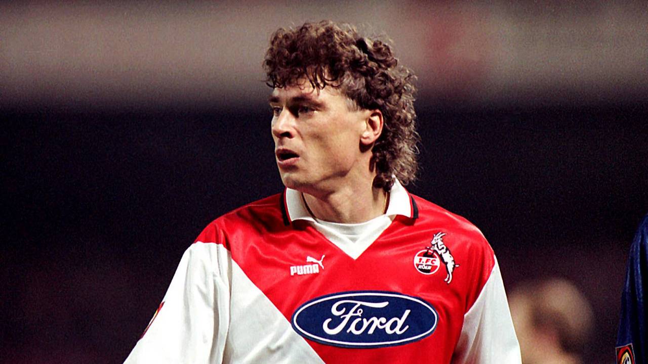 Toni Polster ist fokussiert. Er trägt ein rot-weißes Köln-Trikot von Puma mit dem Ford-Logo auf der Brust.