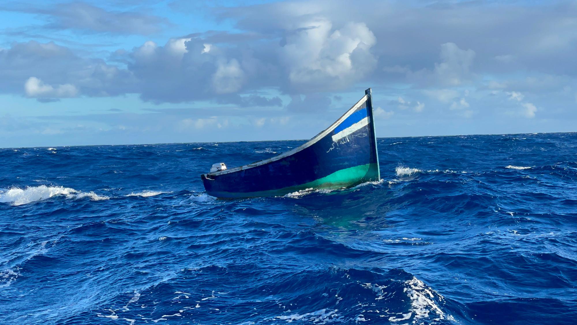 Ein Holzboot treibt auf dem Meer.