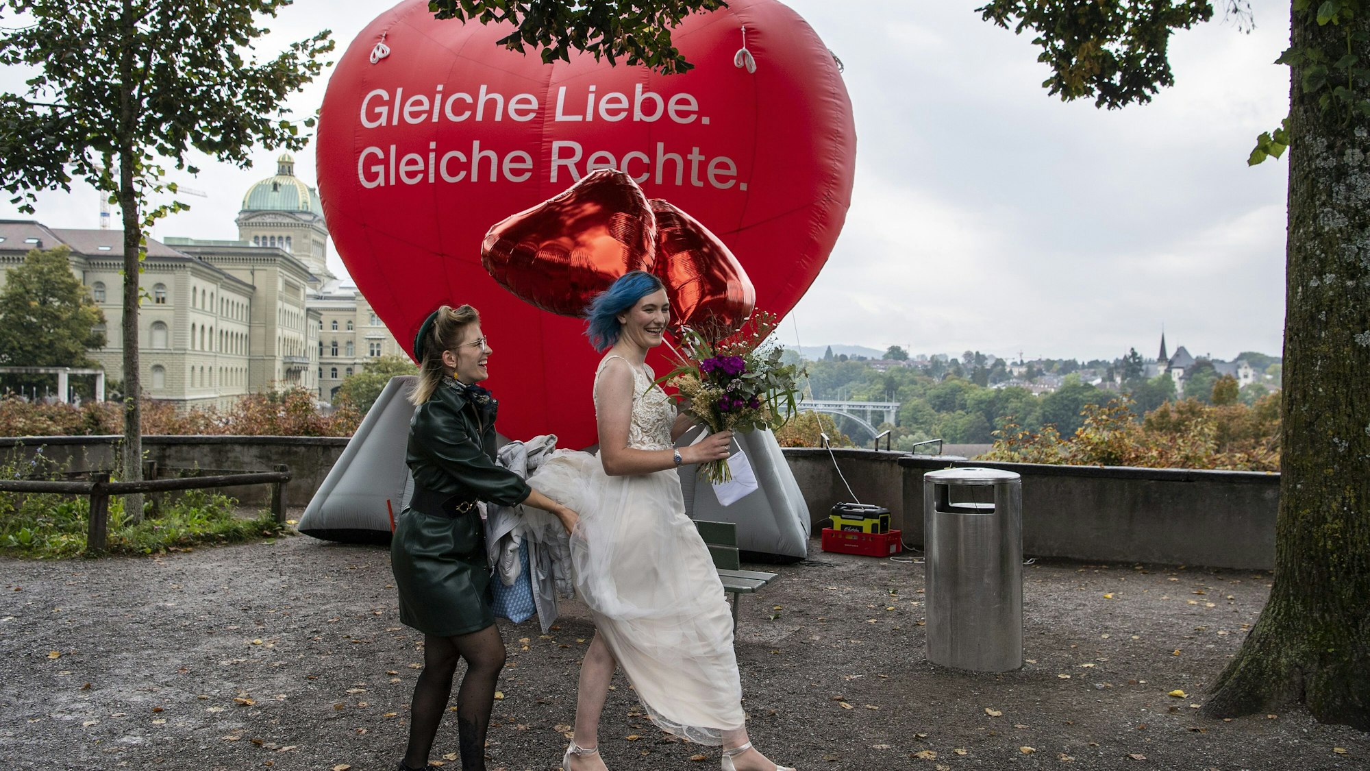 Schweiz, Bern: Eine Frau in einem Brautkleid geht an einem Ballon mit der Aufschrift „Gleiche Liebe. Gleiche Rechte“ vorbei.