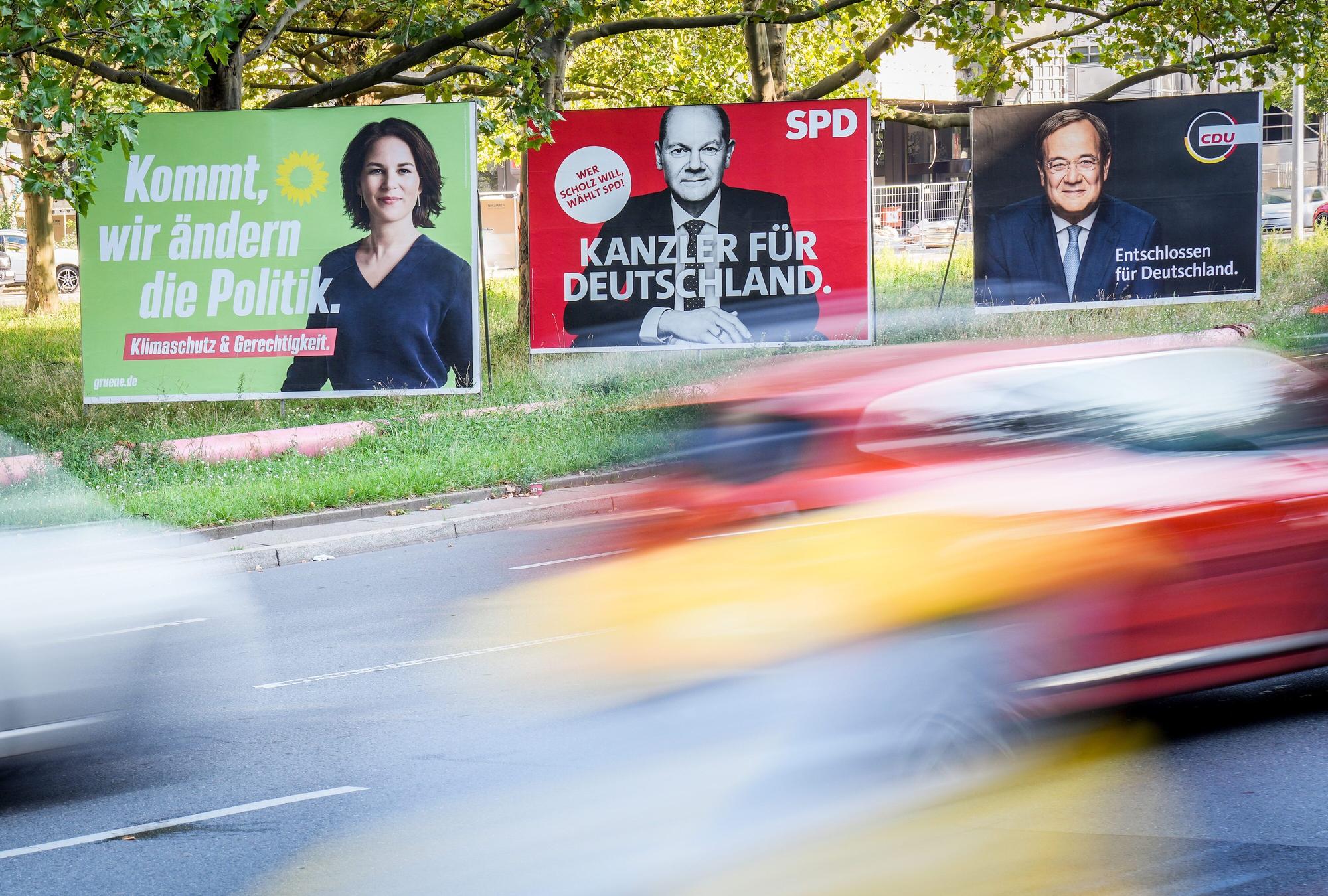 Berlin: Autos fahren an Wahlplakaten von Bündnis 90/Die Grünen, SPD und CDU vorbei.