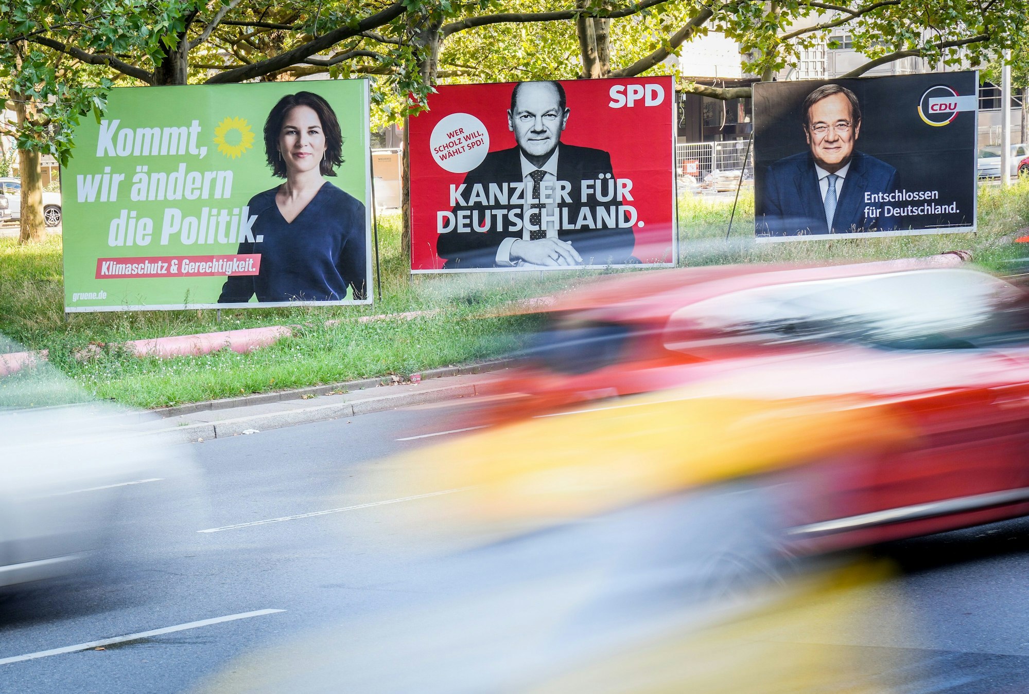 Berlin: Autos fahren an Wahlplakaten von Bündnis 90/Die Grünen, SPD und CDU vorbei.