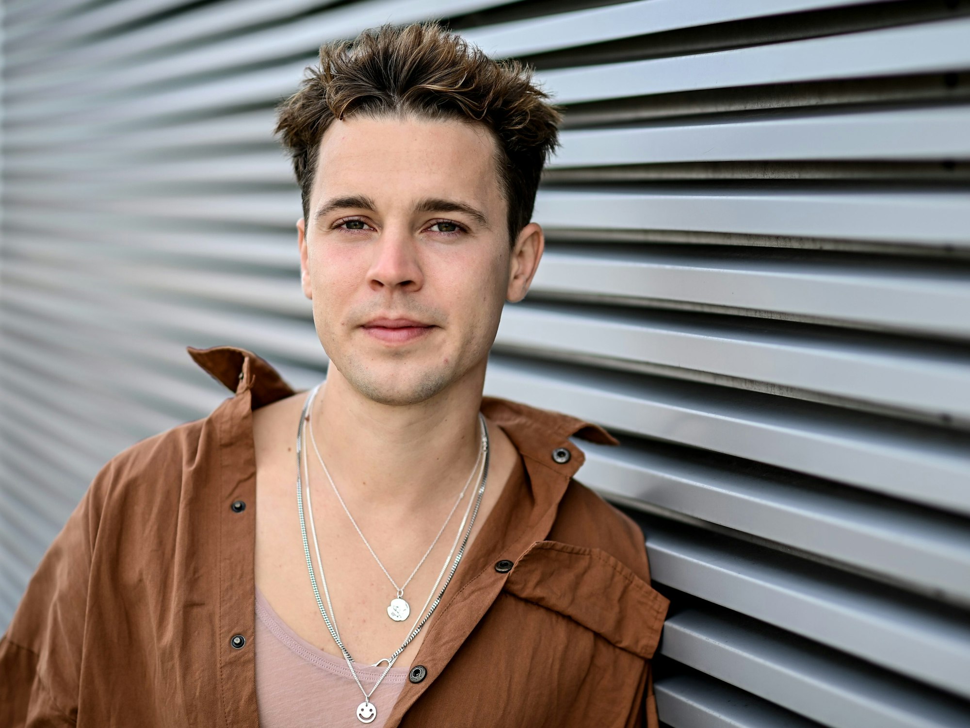 DJ Felix Jaehn schaut in die Kamera und lehnt sich dabei an eine Wand. Der Musiker wird beim CSD in Köln auftreten.