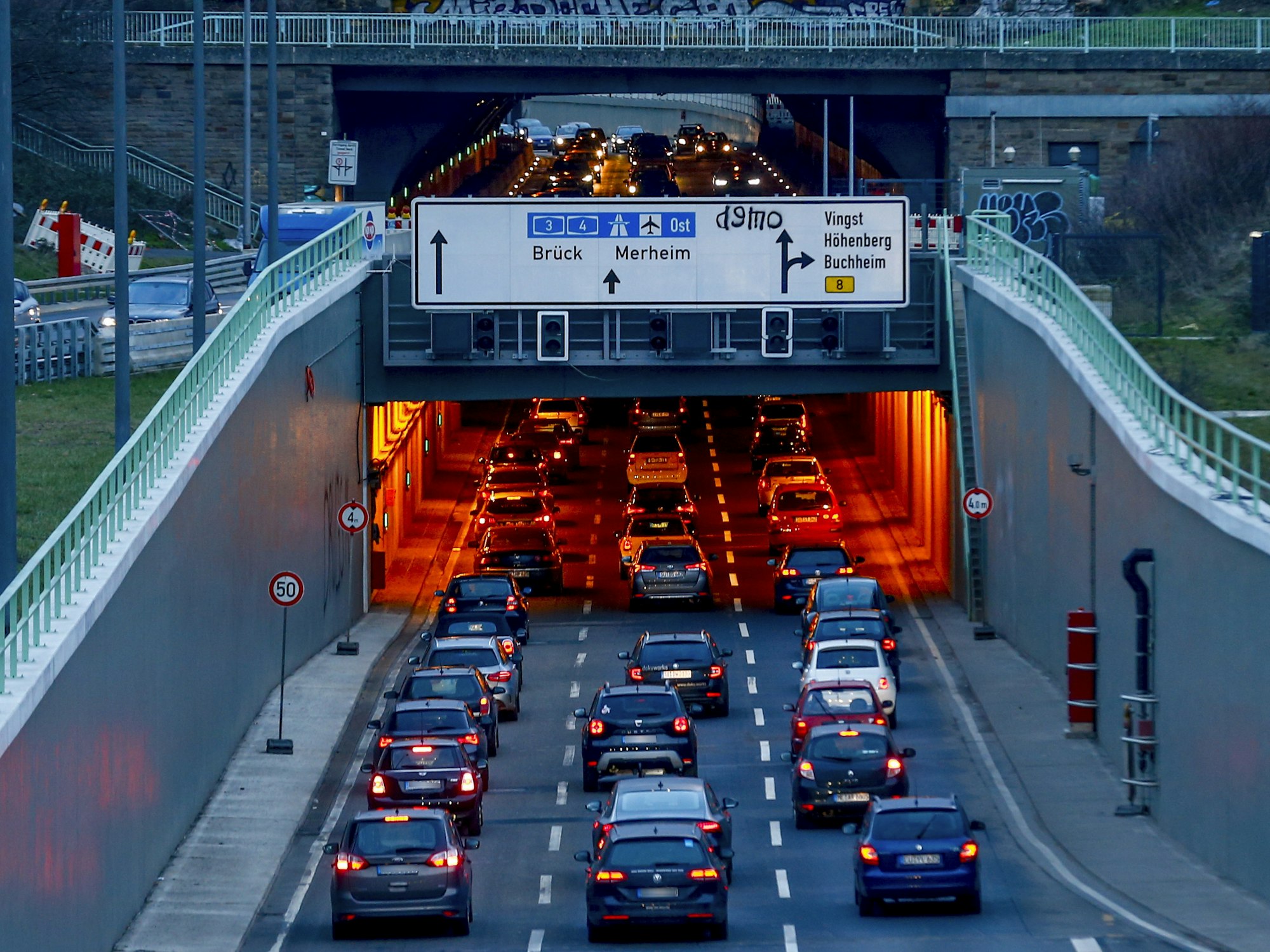 Autos fahren in der Dämmerung in einen Tunnel.