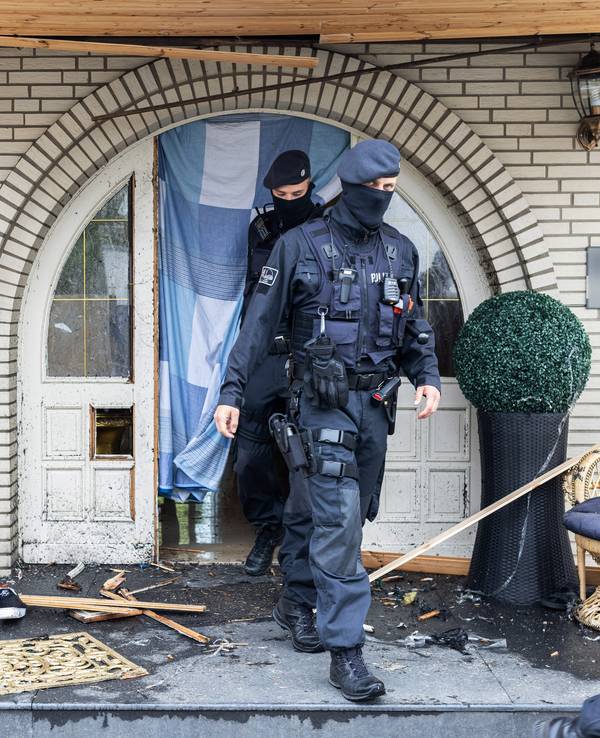 Polizisten verlassen die Leverkusener Villa nach der Razzia.
