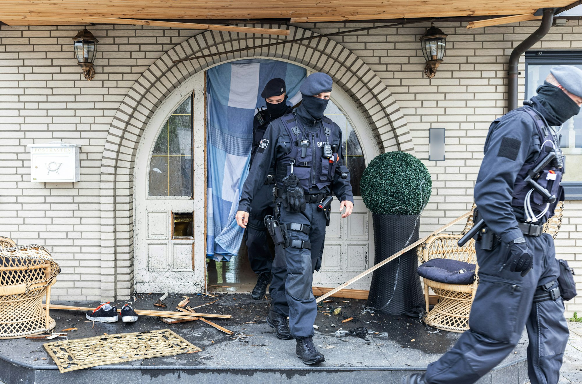 Polizisten verlassen die Leverkusener Villa nach der Razzia.