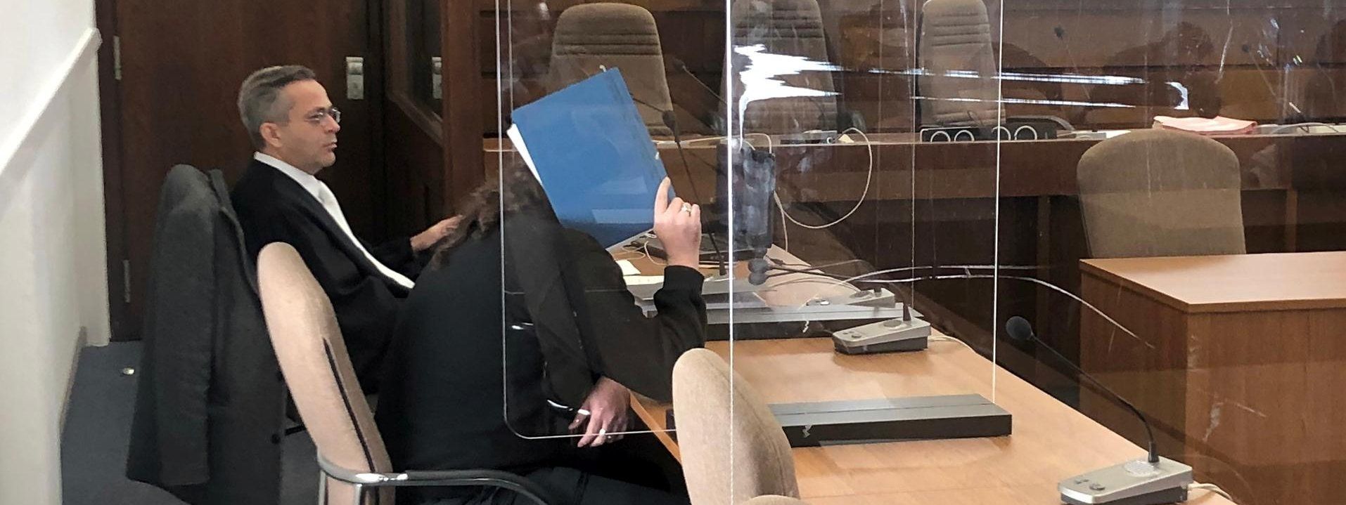 Köln: Der Angeklagte sitzt im Gerichtssaal und verdeckt sein Gesicht mit einer Akte.