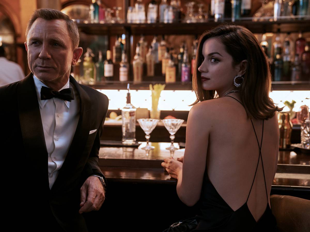 Daniel Craig als James Bond und Ana de Armas als Agentin Paloma stehen in einer Szene des Films „James Bond 007 - Keine Zeit zu sterben“ an einer Bar.