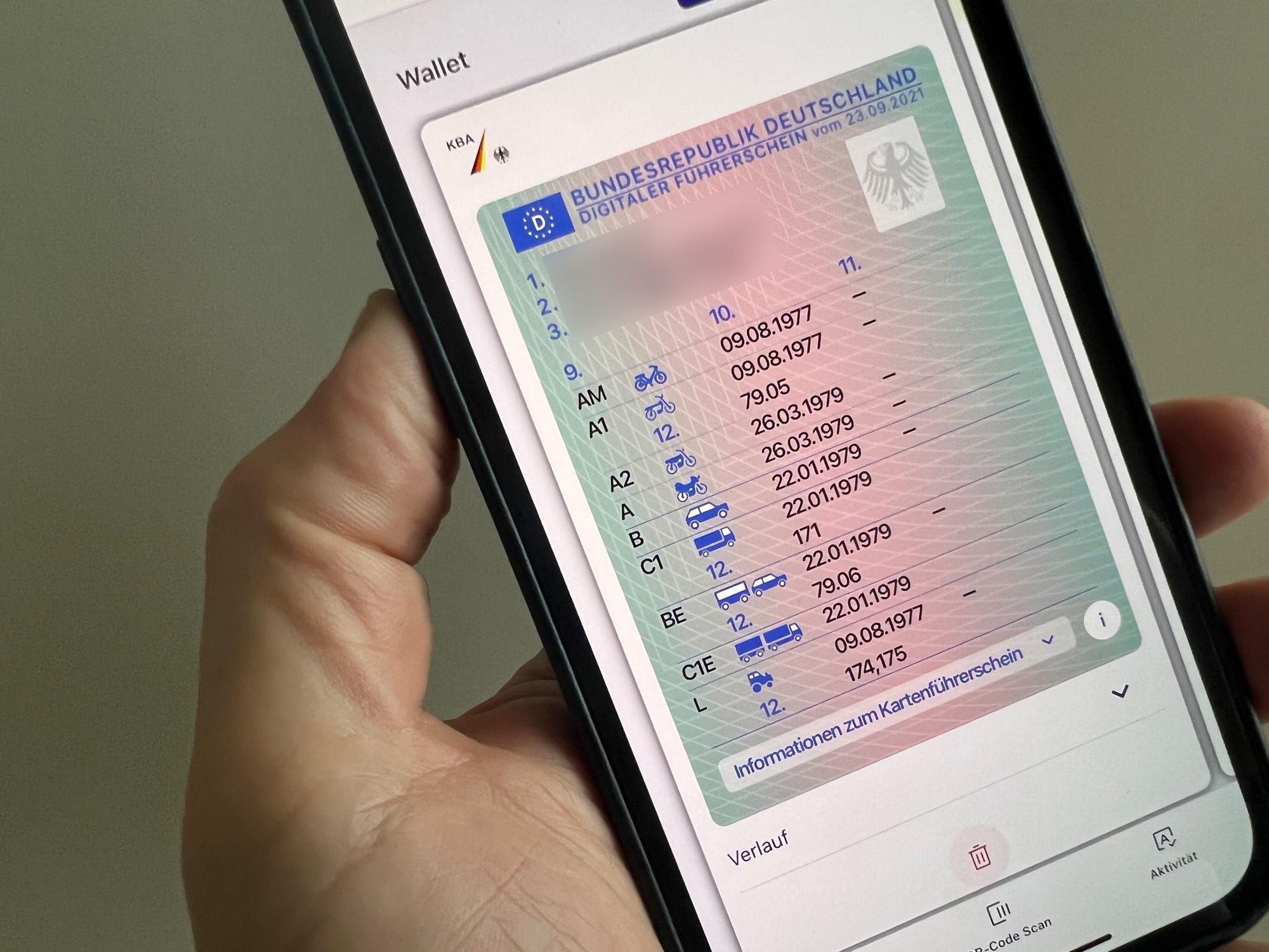 Ein Mann hält ein iPhone mit der App "ID Wallet", in der die digitale Variante eines Führerscheins zu sehen ist.