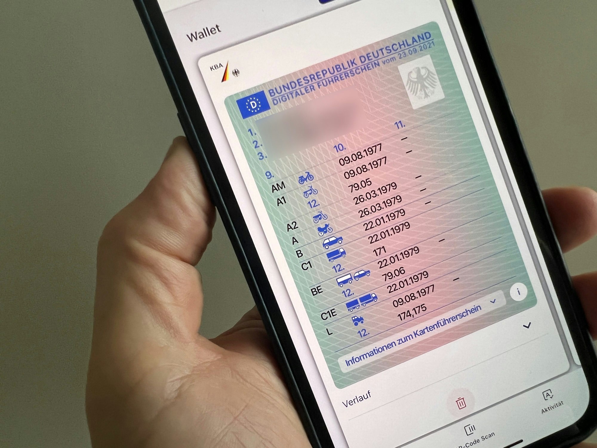 Ein Mann hält ein iPhone mit der App "ID Wallet", in der die digitale Variante eines Führerscheins zu sehen ist.