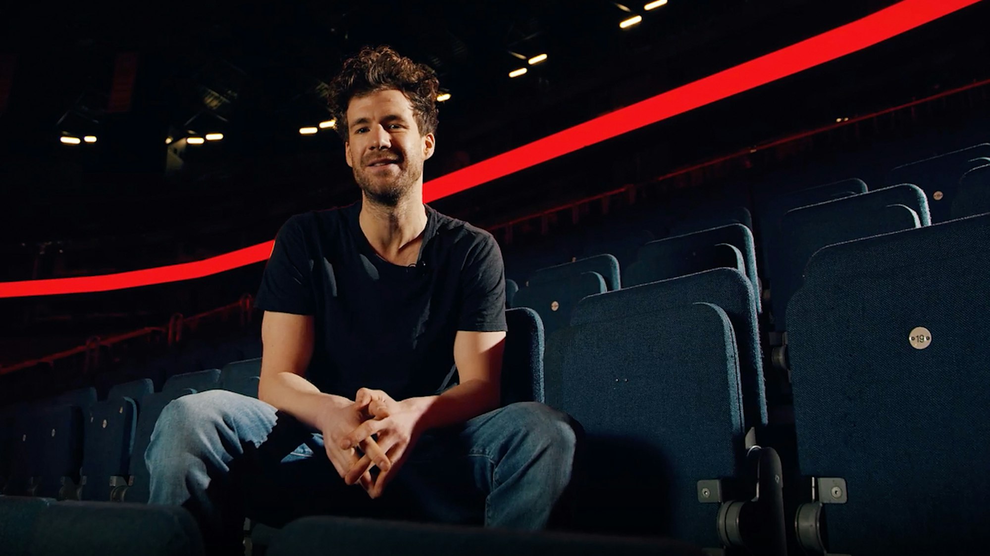 Luke Mockridge sitzt auf einem Stuhl in der Lanxess-Arena.