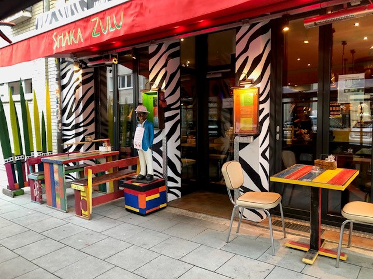 Der Eingang des Shaka Zulu ist bunt bemalt und mit bunter Außengastronomie bestückt.