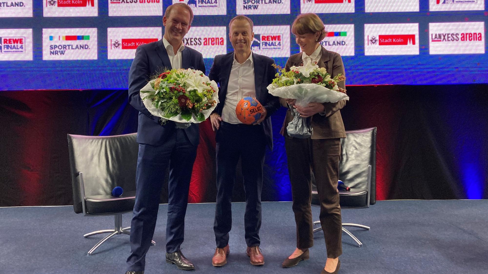 Pressetermin mit Blumen: Stefan Löcher, Frank Bohmann und Henriette Reker.