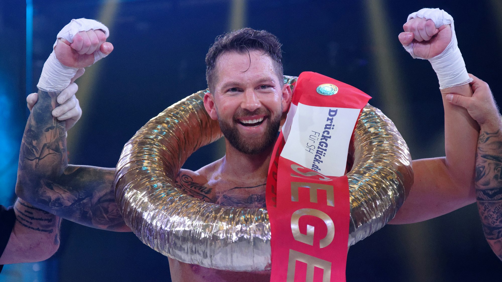 Oliver Sanne streckt seine Hände siegessicher, bei der TV-Show „Das große Sat.1 Promiboxen“, in die Höhe.