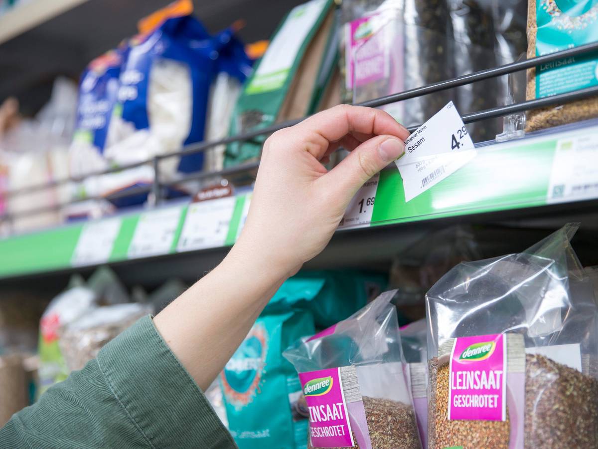 Eine Filialleiterin bestückt vor der Öffnung am frühen Morgen die Regale mit neuer Ware und setzt ein Preisschild ein. Die Inflation in Deutschland hat im September erstmals seit knapp 28 Jahren wieder die Vier-Prozent-Marke überschritten.