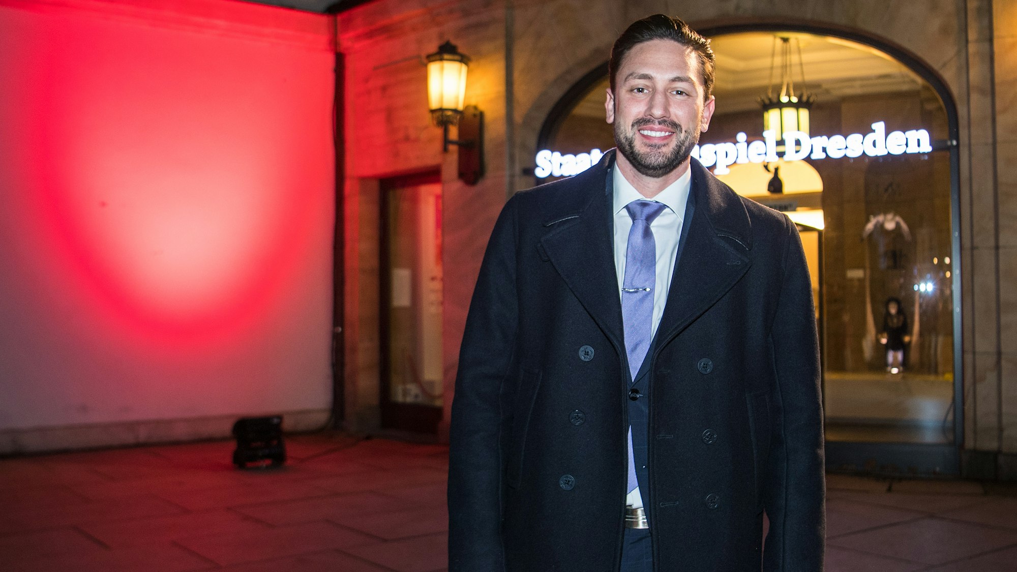 Daniel Völz steht im Anzug vor dem Schauspielhaus in Dresden.