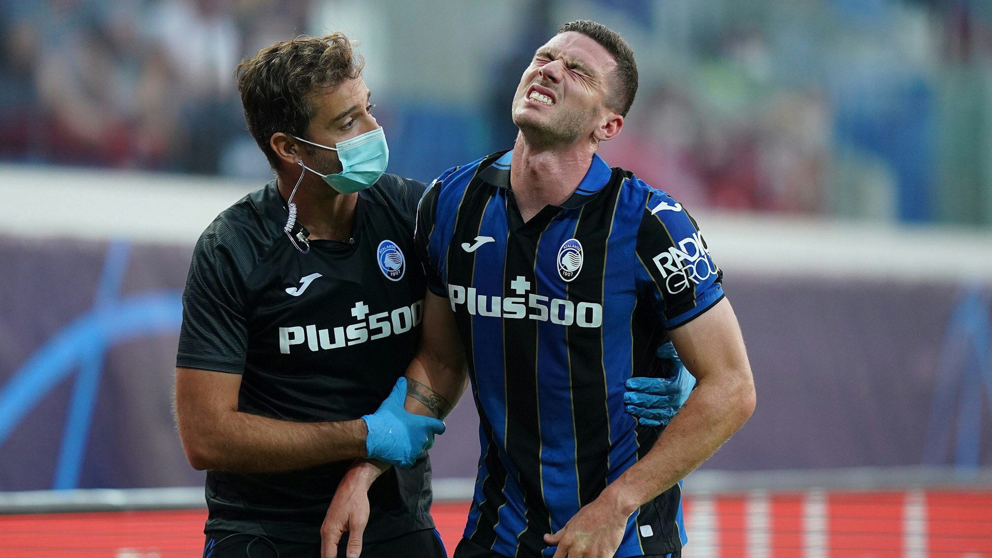 Der verletzte Deutsche Robin Gosens (r) von Bergamo wird vom Platz geführt.