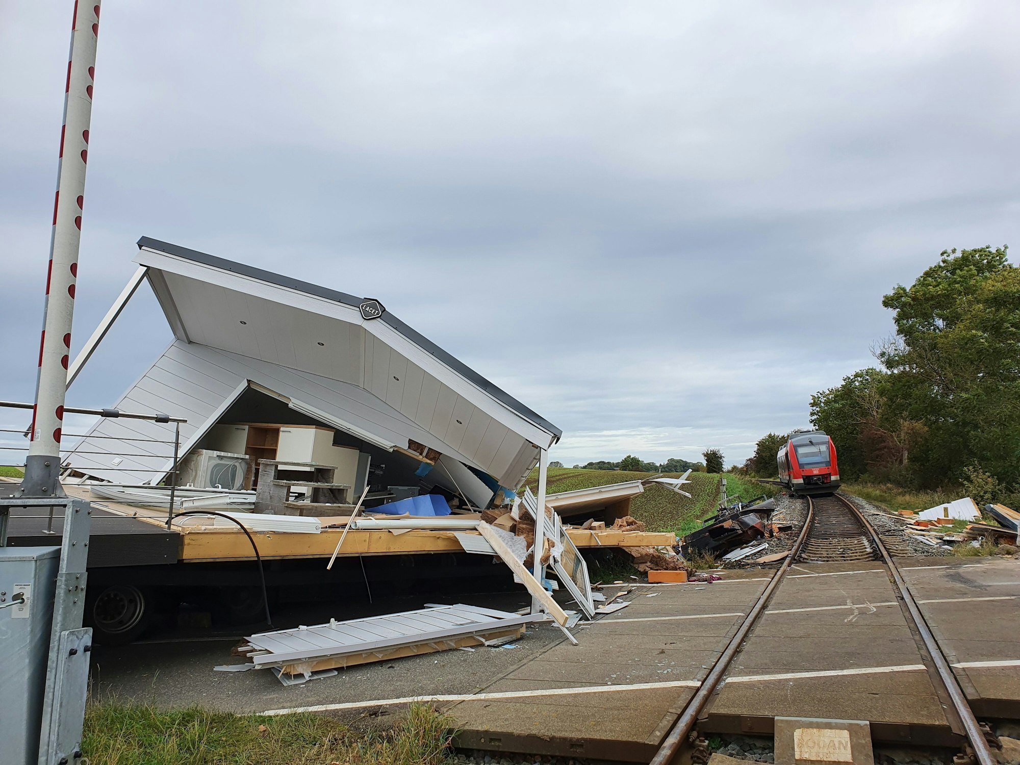 Ein zerstörtes Fertighaus liegt am Bahnübergang Sütel in Ostholstein (Schleswig-Holstein). Der mit dem Haus beladene Schwertransporter war in der Nacht zum Freitag (1. Oktober 2021) dort steckengeblieben und wurde von einem Regionalzug gerammt.