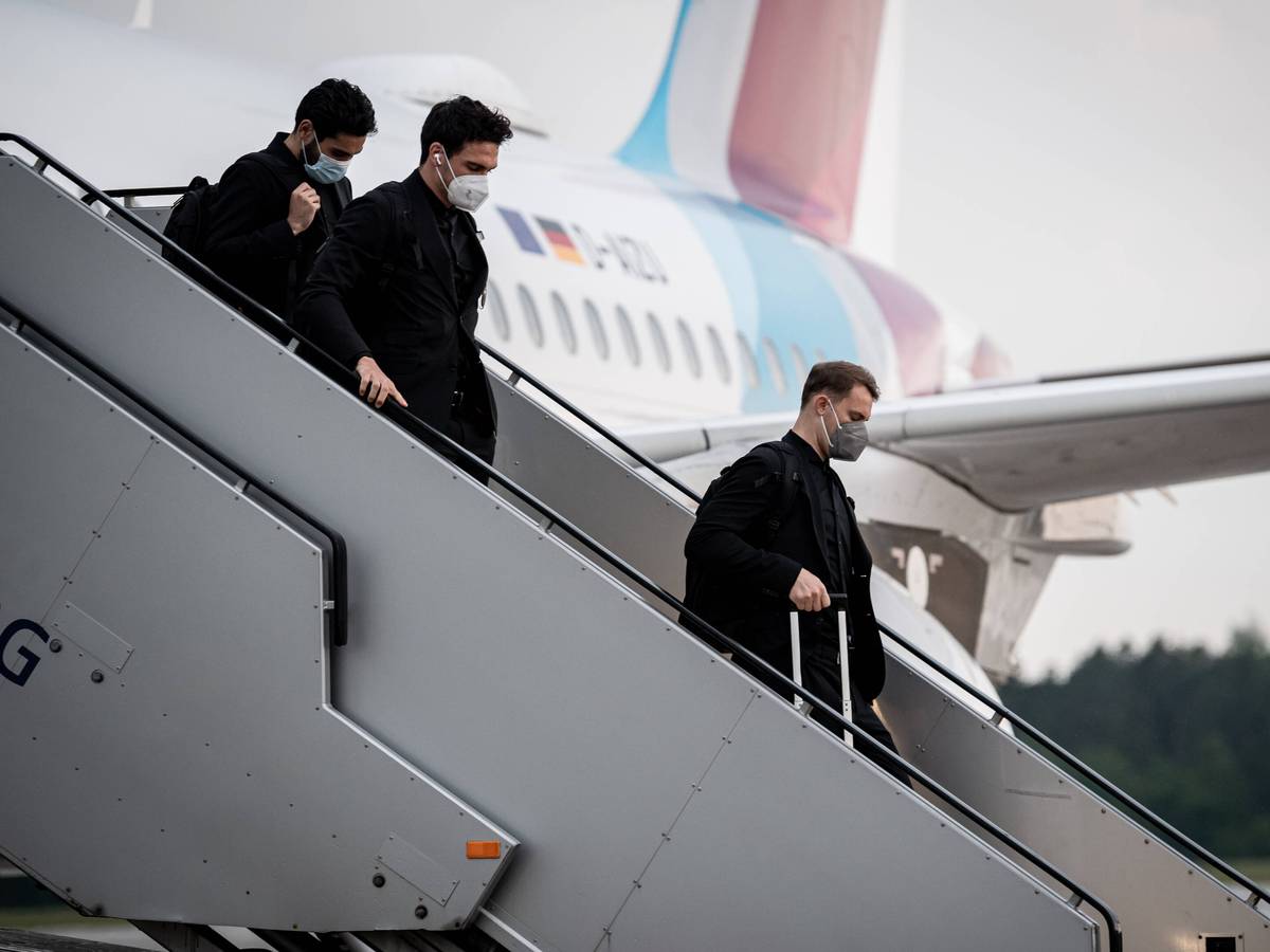 Manuel Neuer, Mats Hummels und Ilkay Gündogan gehen die Treppe am Flugzeug herunter.