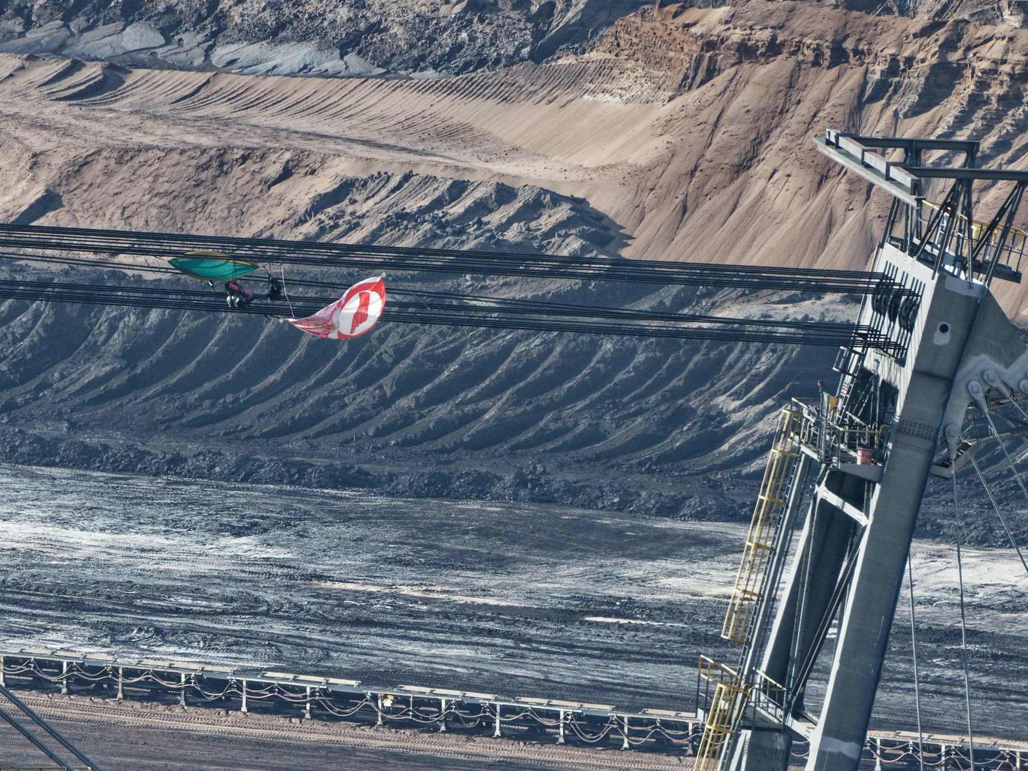 Eine Fahne und Ausrüstungsgegenstände hängen in den Seilen eines Absetzers im Braunkohletagebau Garzweiler II.