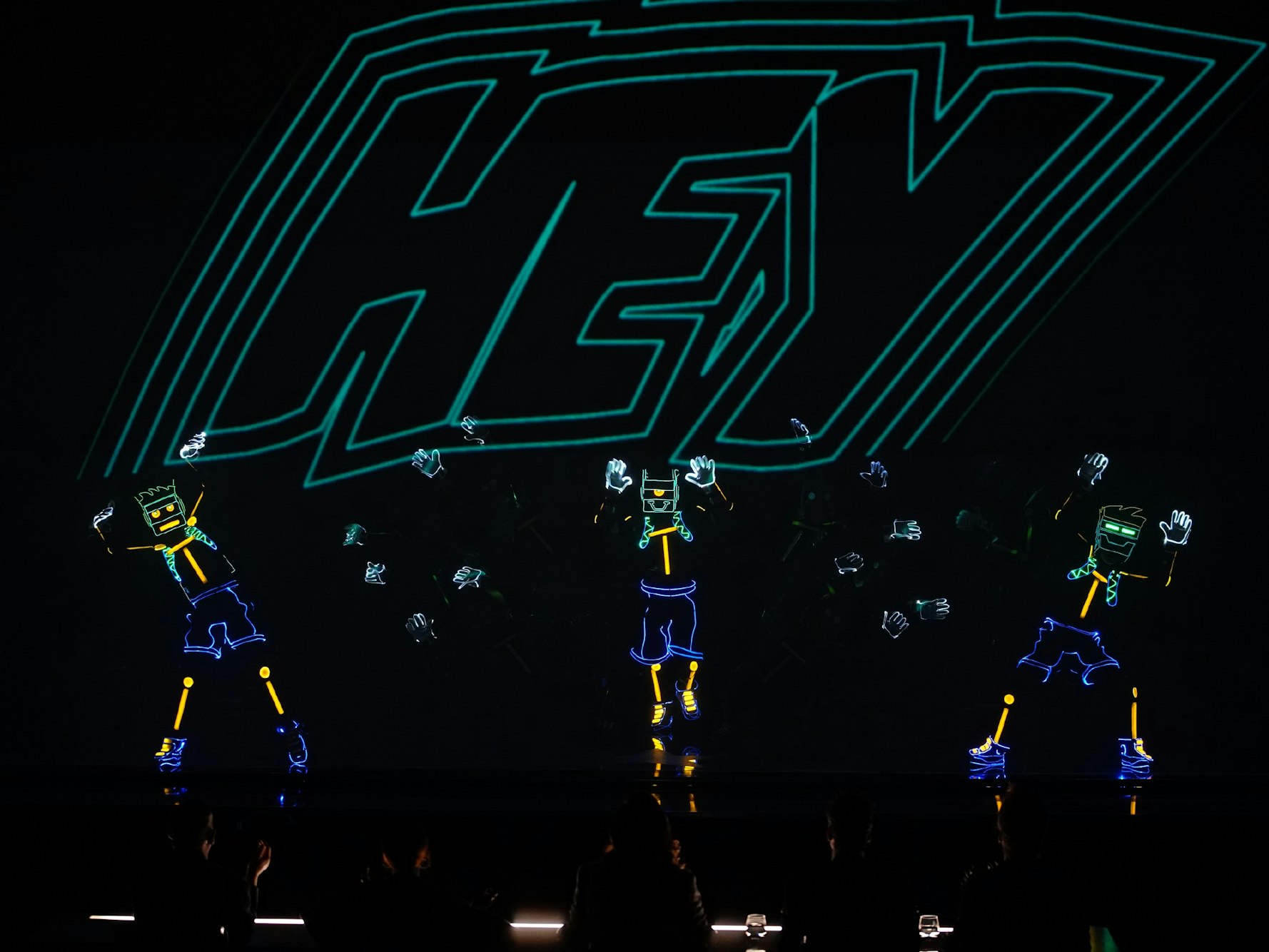 Maryna Zaitseva und die Light Balance Kids führen ihre Tanzdarbietung im Schwarzlichtmodus auf.