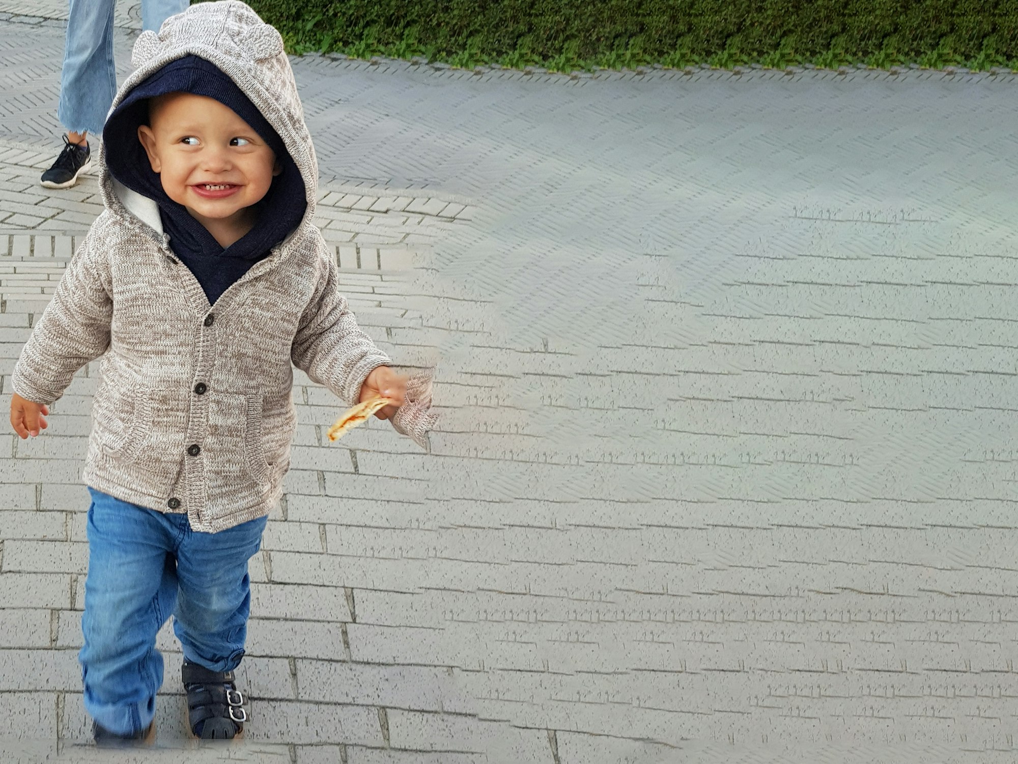 Maxim (2) aus Düsseldorf läuft auf einer Straße.