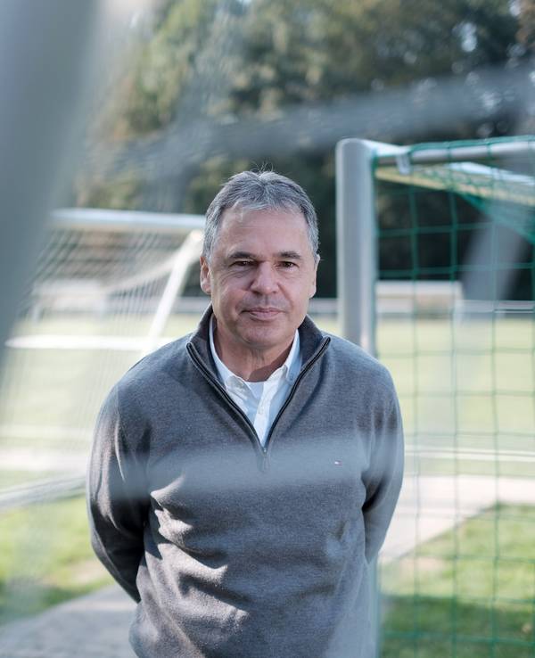 Andreas Rettig seht auf einem Fußballplatz.