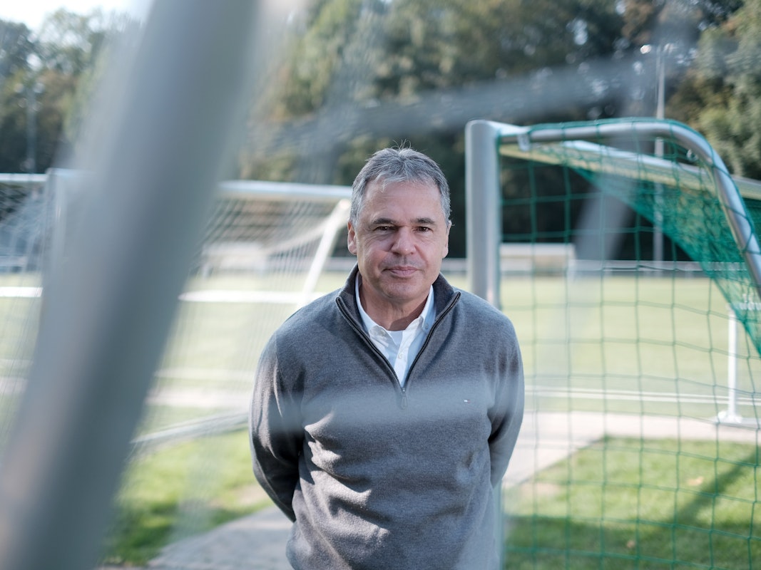 Andreas Rettig seht auf einem Fußballplatz.