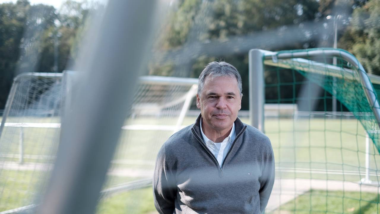 Andreas Rettig seht auf einem Fußballplatz.
