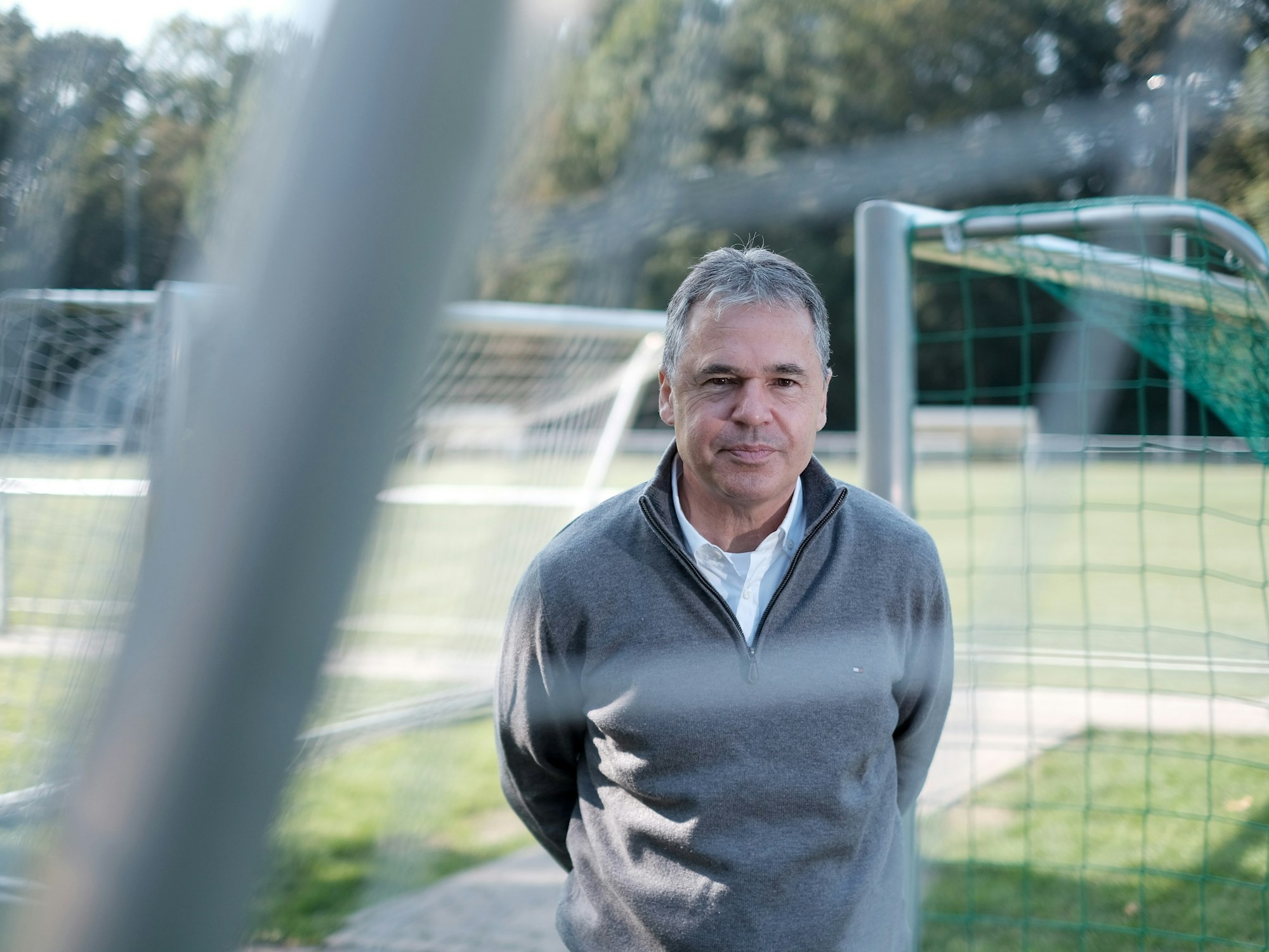Andreas Rettig seht auf einem Fußballplatz.