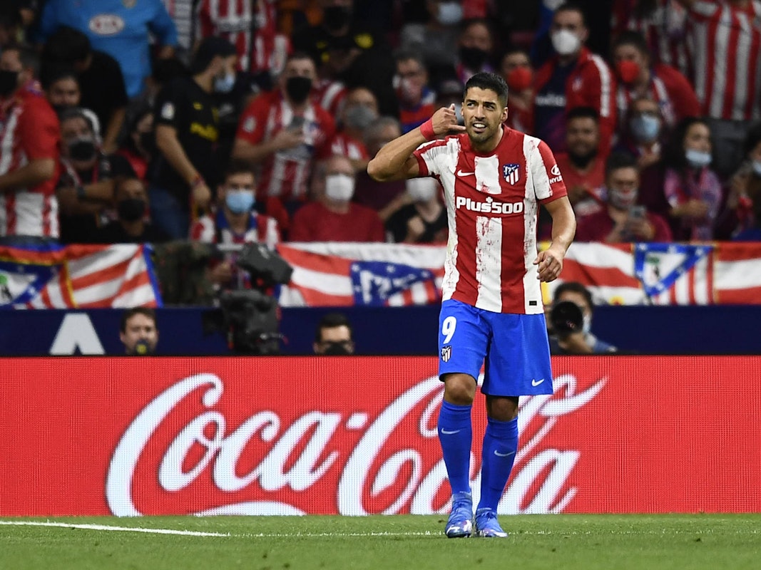 Luis Suárez blickt, während er eine Telefon-Geste macht, auf die Tribüne.