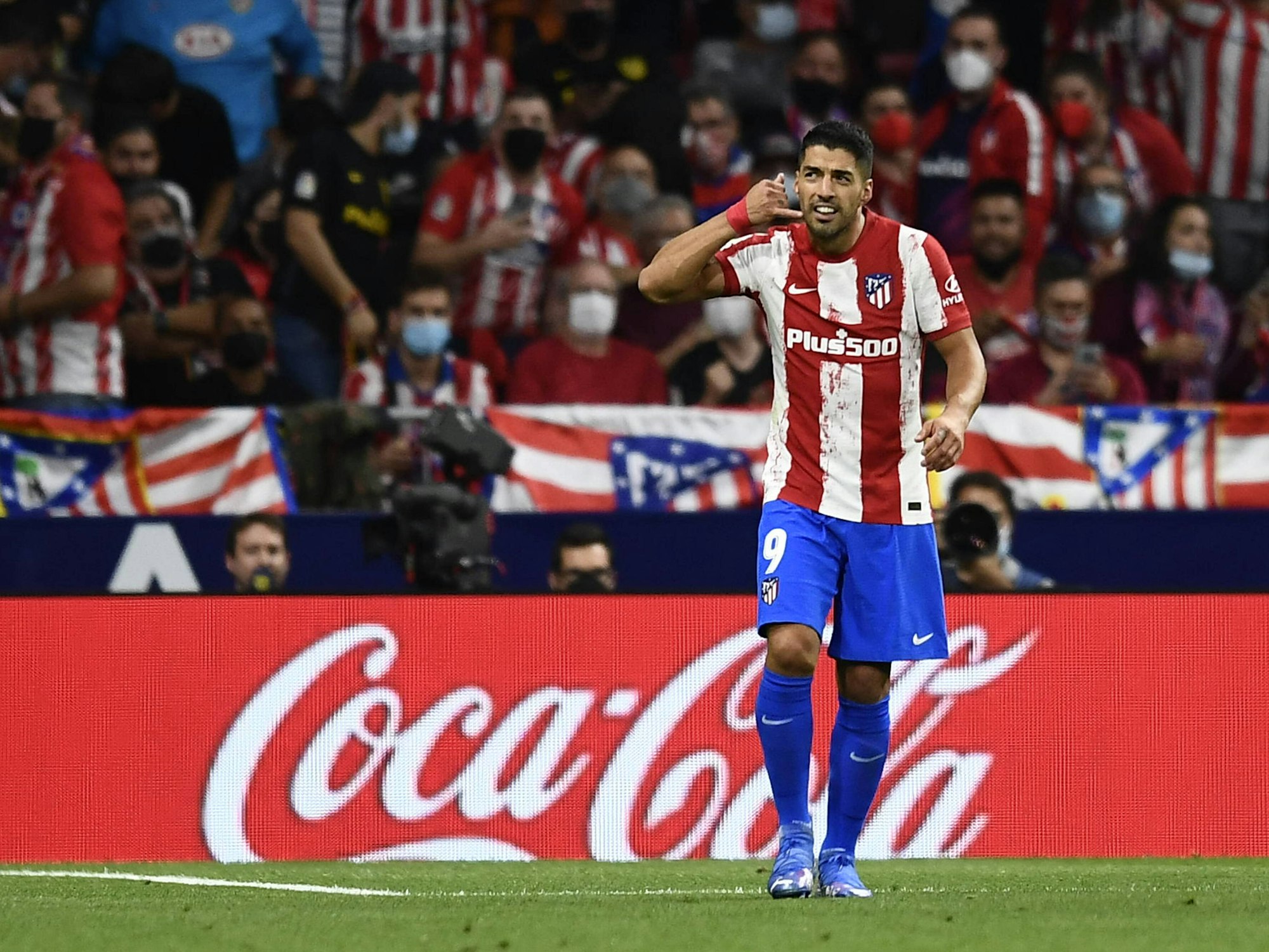 Luis Suárez blickt, während er eine Telefon-Geste macht, auf die Tribüne.