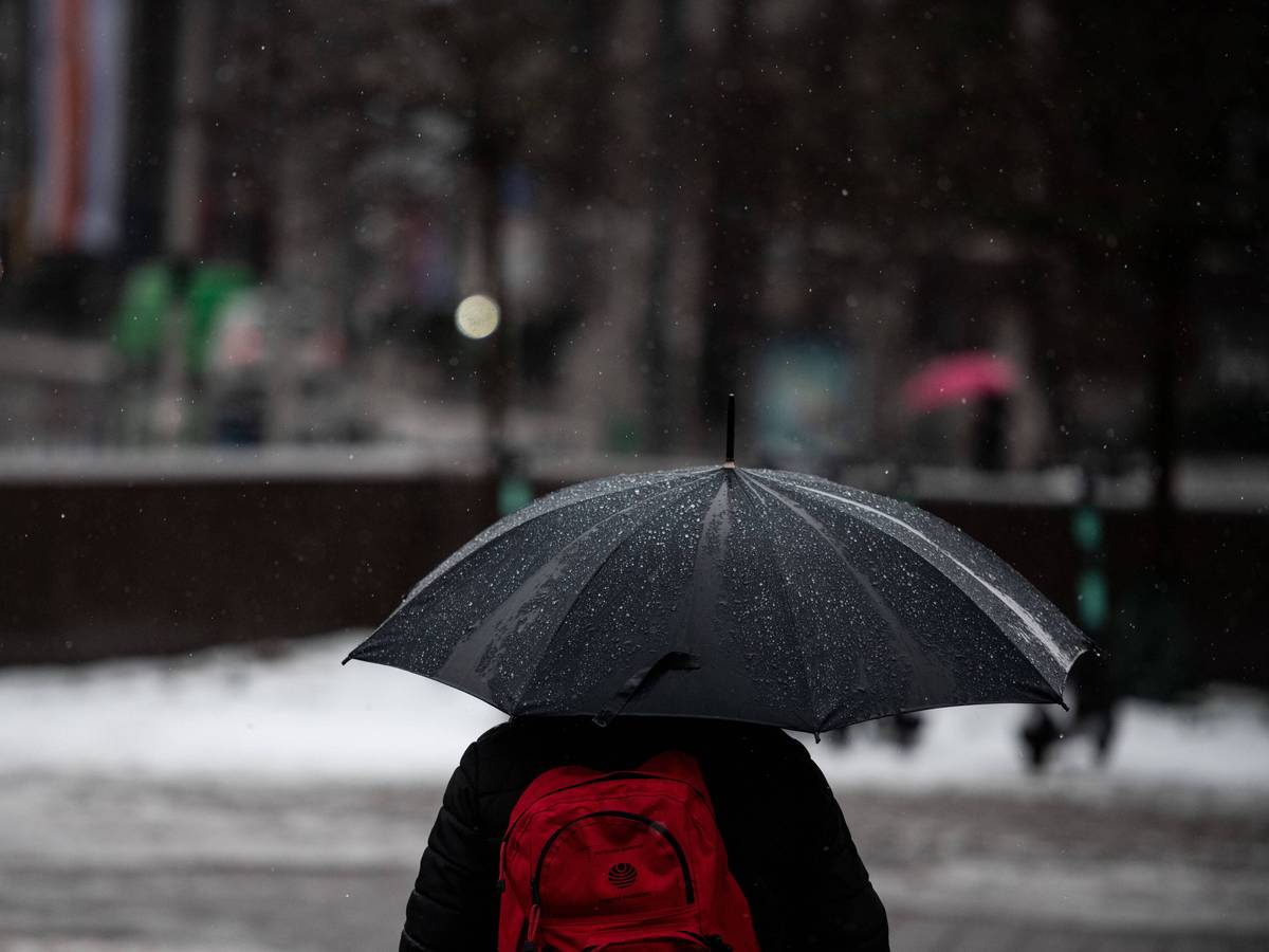 Düsseldorf: Ein Mann läuft mit Regenschirm durch den Regen in der Düsseldorfer Innenstadt.