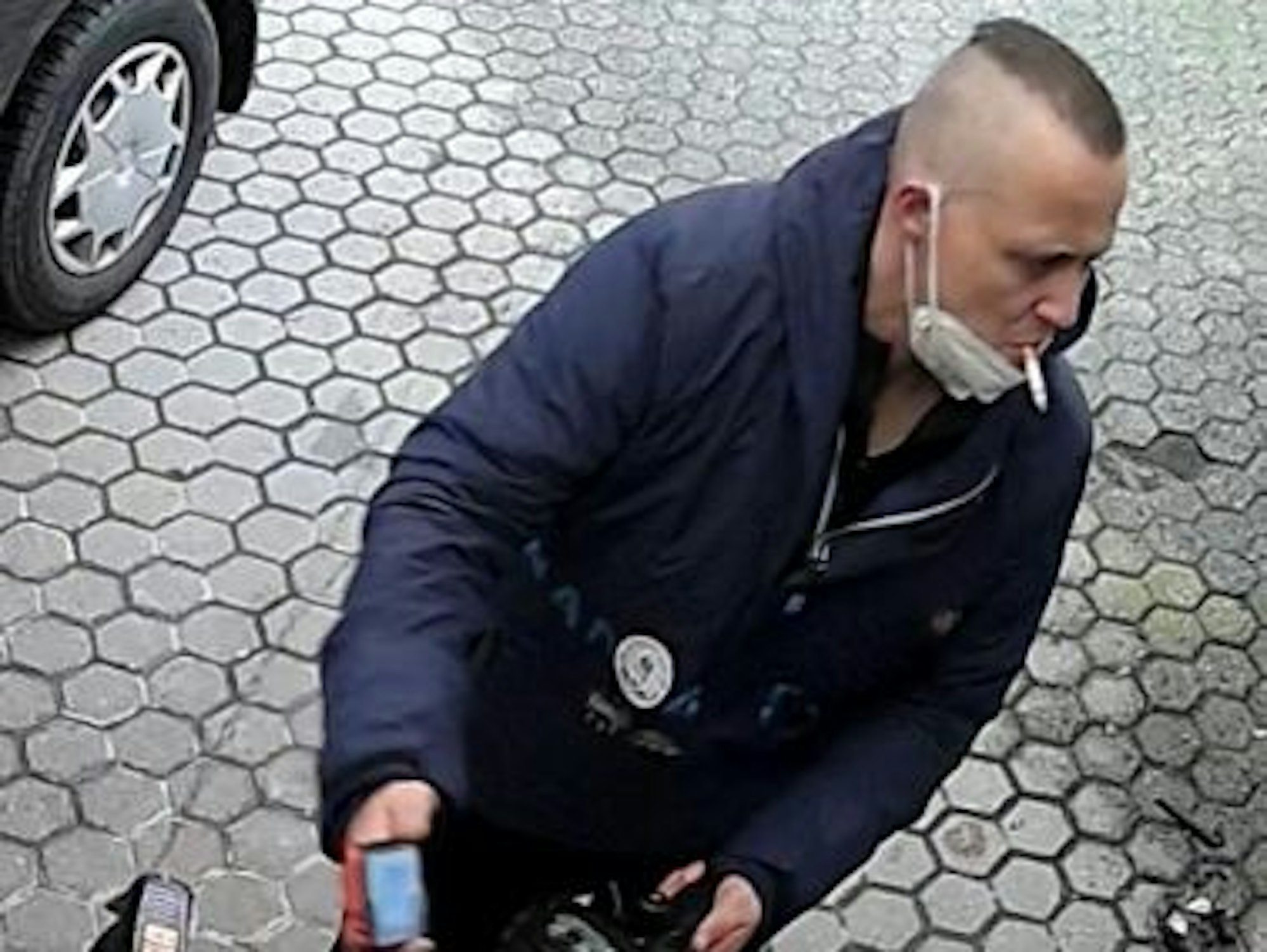 Der Tatverdächtige steht auf dem Parkplatz und raucht eine Zigarette.