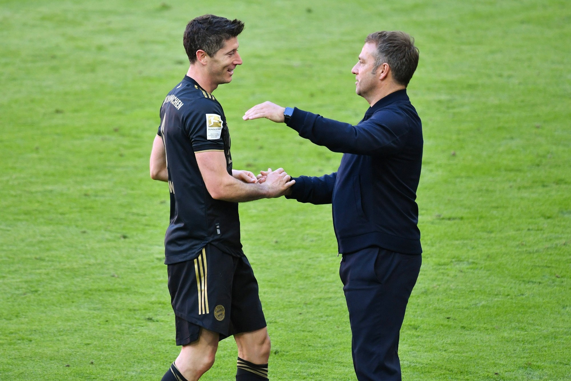 Robert Lewandowski geht auf Hansi Flick zu. Beide umarmen sich wenige Sekunden später.