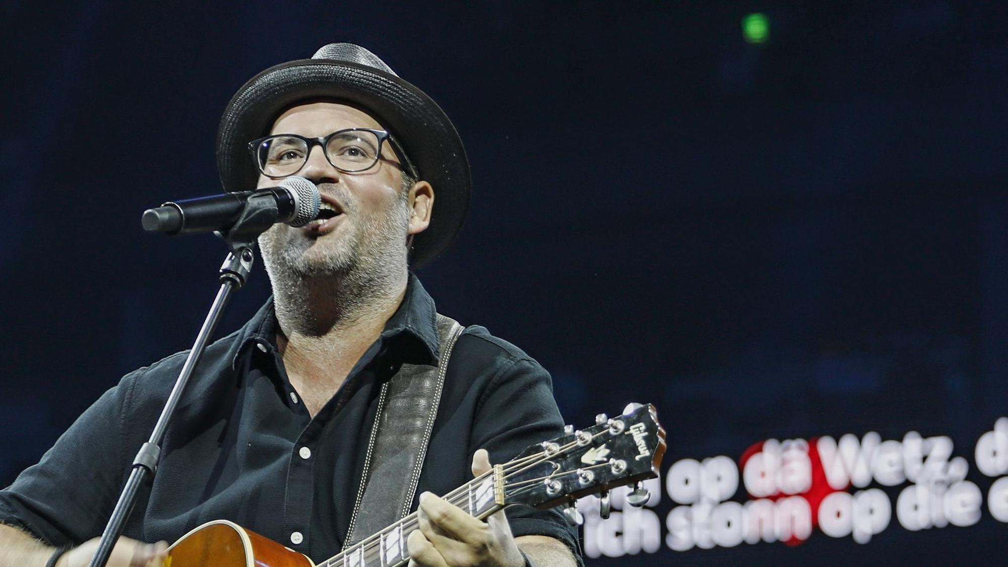 Björn Heuser spielt Gitarre und singt in der Lanxess-Arena.
