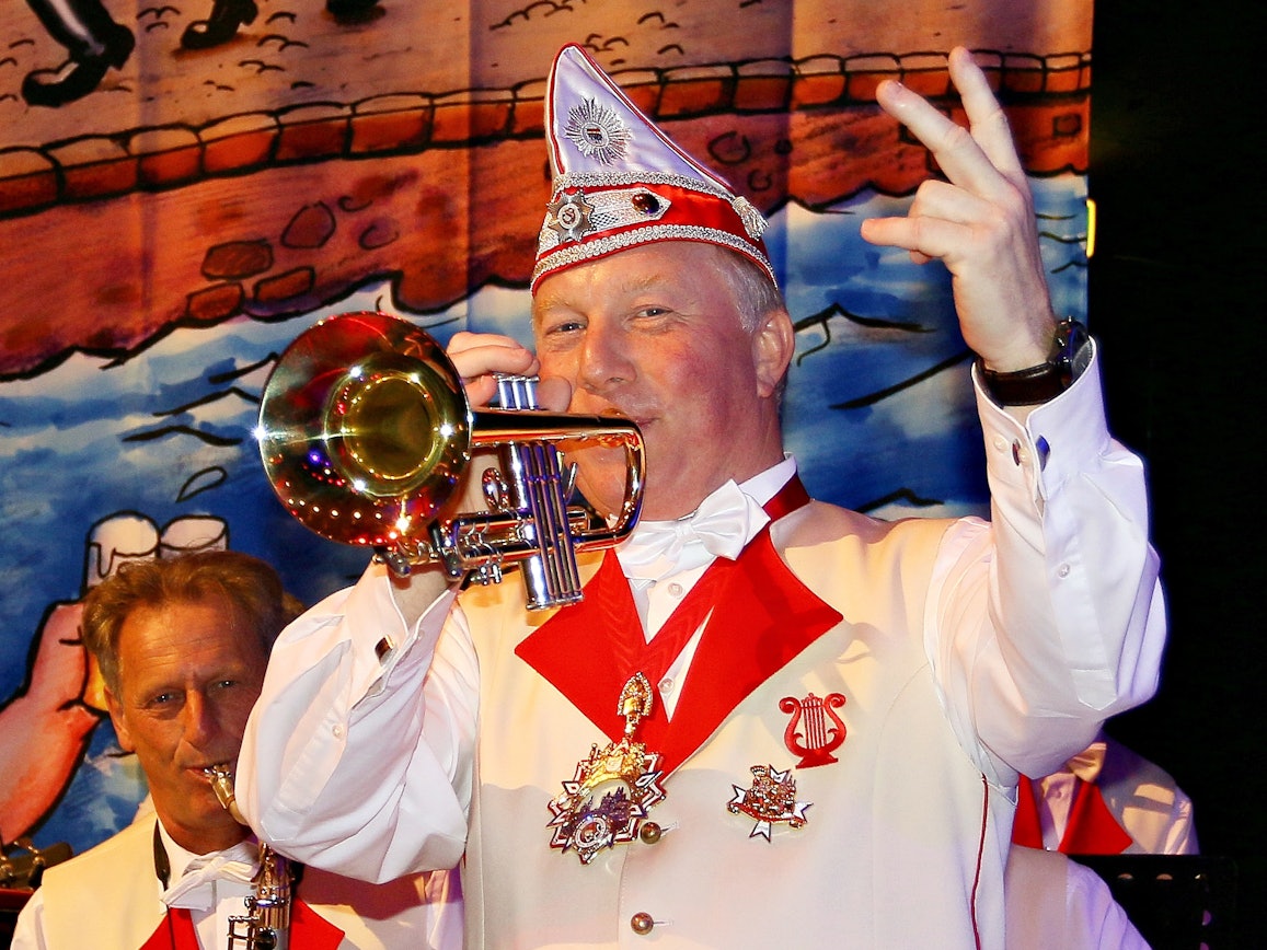 Helmut Blödgen spielt mit einer Hand Trompete, mit der anderen zählt er ein.
