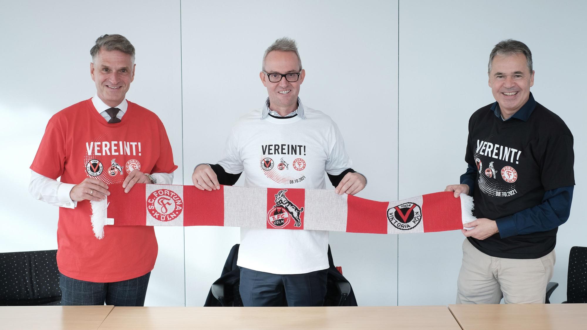 Andreas Rettig, Alexander Wehrle und Hanns-Jörg Westendorf (v.r.) demonstrieren gemeinsam mit dem „Mottoschal“ und T-Shirt Einigkeit.