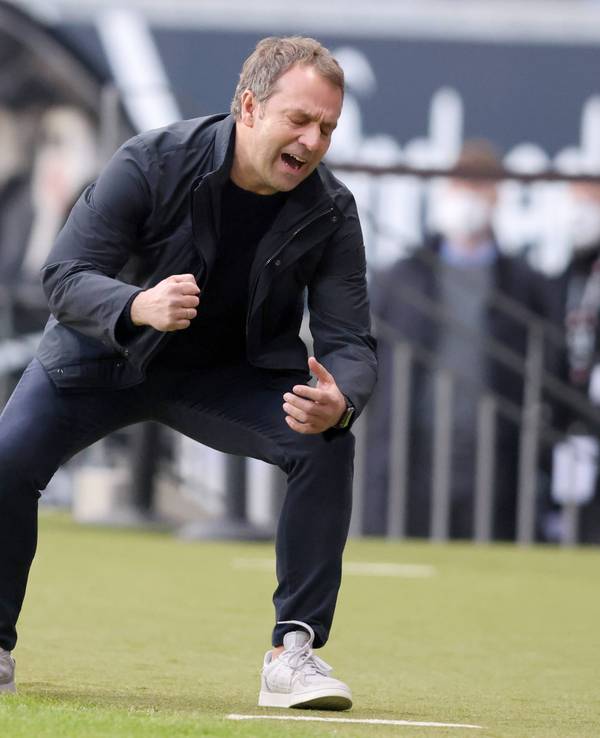 Hansi Flick krümmt sich, geht in die Hocke.