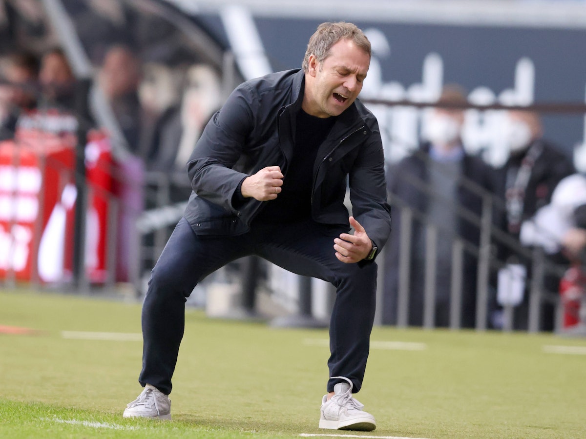 Hansi Flick krümmt sich, geht in die Hocke.