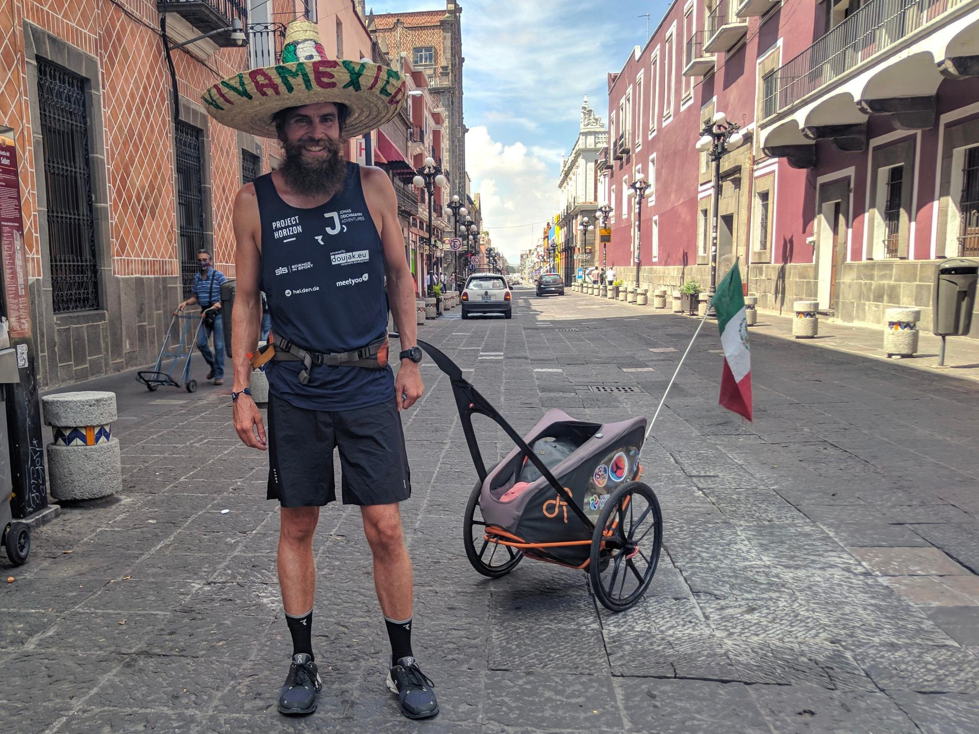 Jonas Deichmann posiert mit Sombrero und mexikanischer Flagge für ein Foto, nachdem er bei seiner Weltumrundung am 17.08.2021 Mexiko zu Fuß durchquert hat.