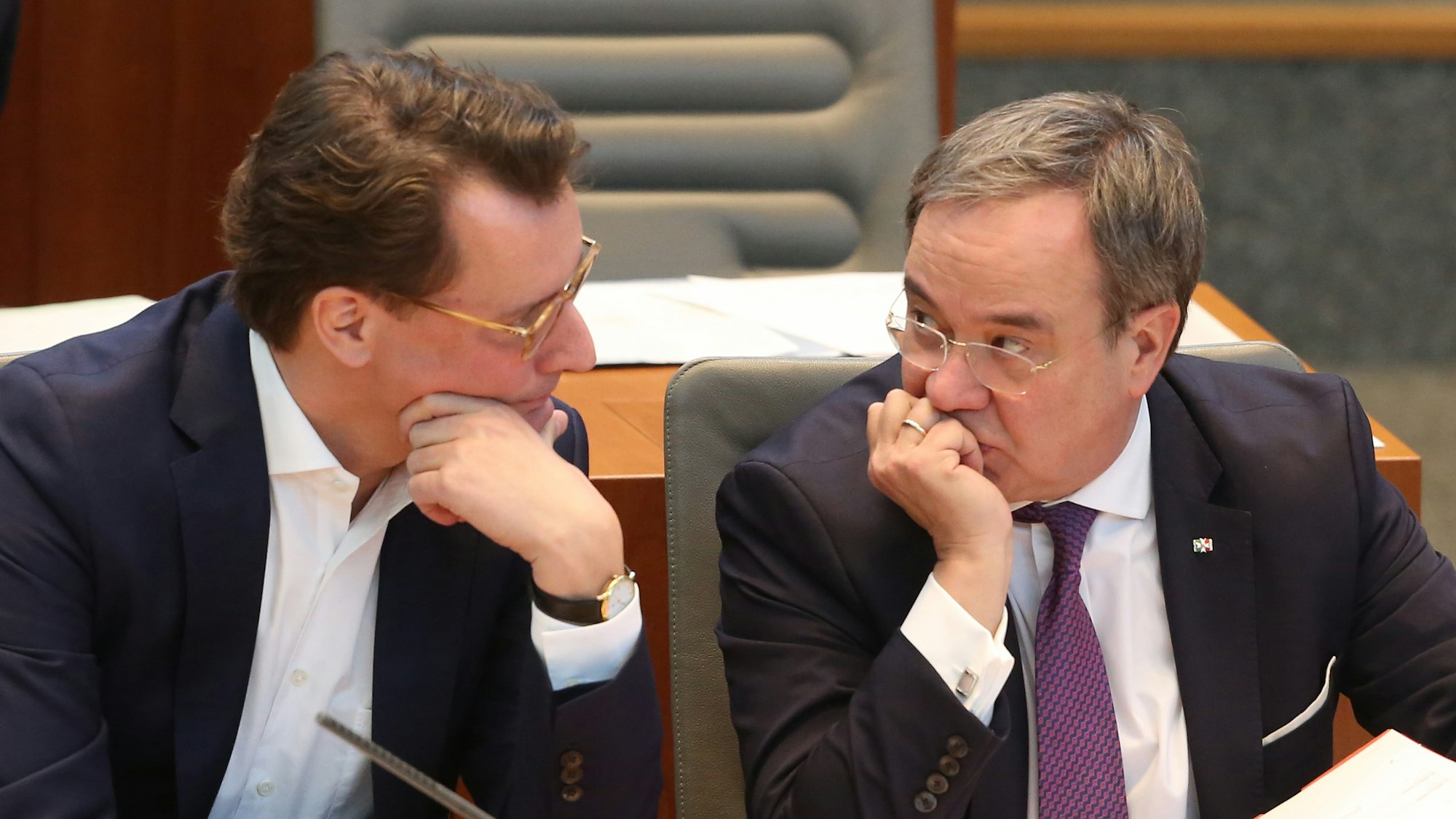Der nordrhein-westfälische Verkehrsminister Hendrik Wüst (CDU, l) spricht auf der Ministerbank mit Ministerpräsident Armin Laschet (CDU). Themen der Plenarsitzung sind unter anderem die Wasserstofftechnologie, ein Tempolimit auf Autobahnen und das Wahlrecht ab 16 Jahren.