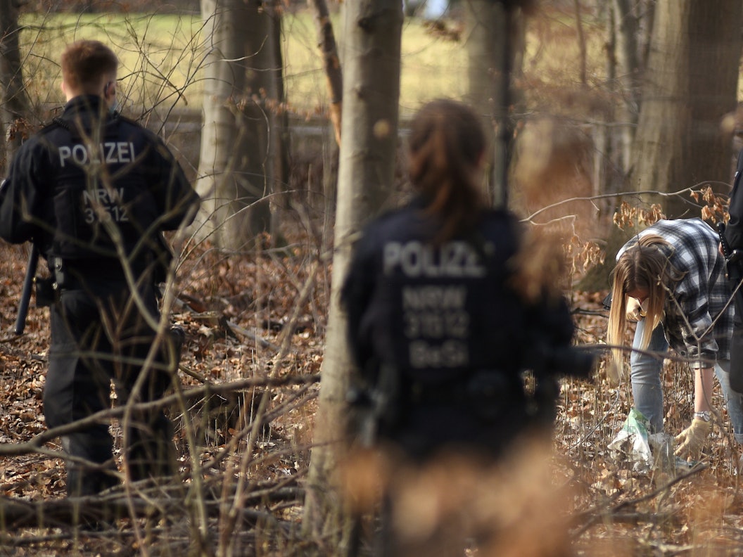 Polizeieinheiten durchsuchen einen Wald.