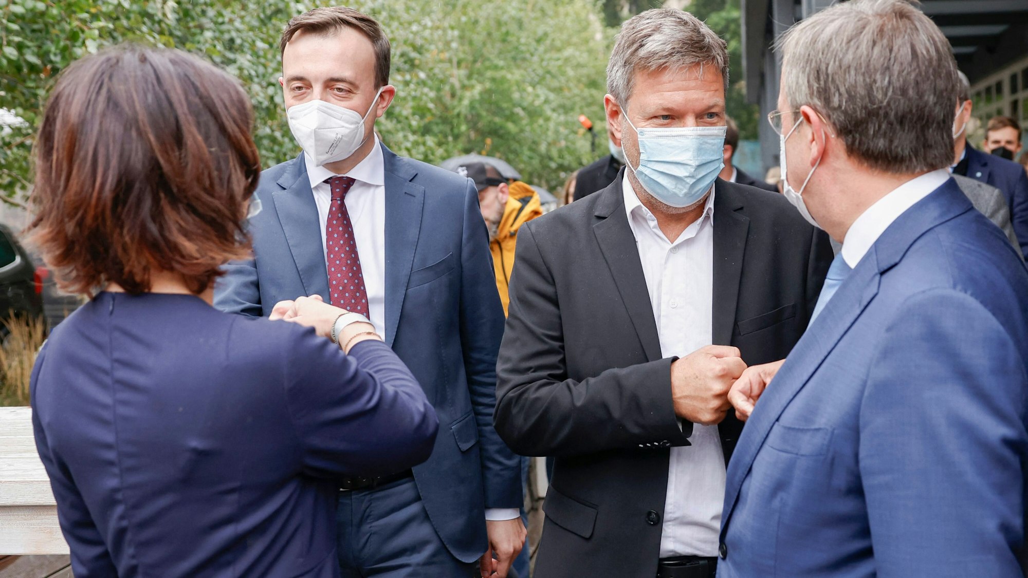 Armin Laschet, CDU-Bundesvorsitzender und Ministerpräsident von Nordrhein-Westfalen, Robert Habeck, Bundesvorsitzender von Bündnis 90/Die Grünen, CDU-Generalsekretär Paul Ziemiak und Annalena Baerbock, Bundesvorsitzende von Bündnis 90/Die Grünen machen schlagen ihre Fäuste aneinander.
