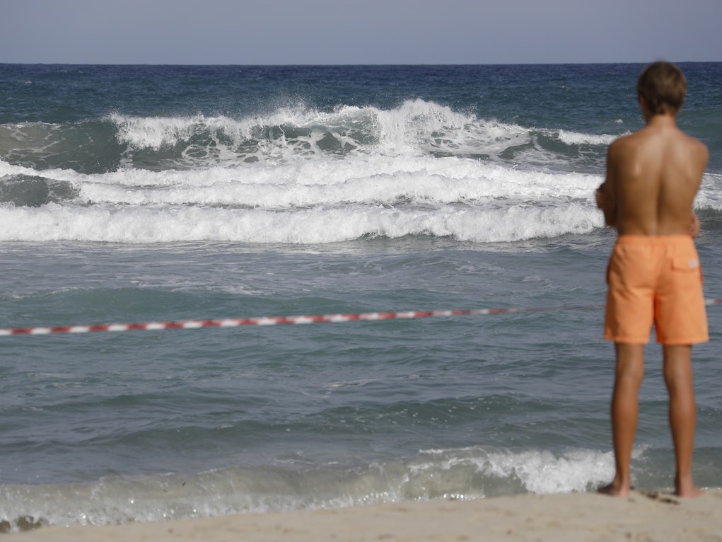 Ein Mann steht an einem abgesperrten Strand.