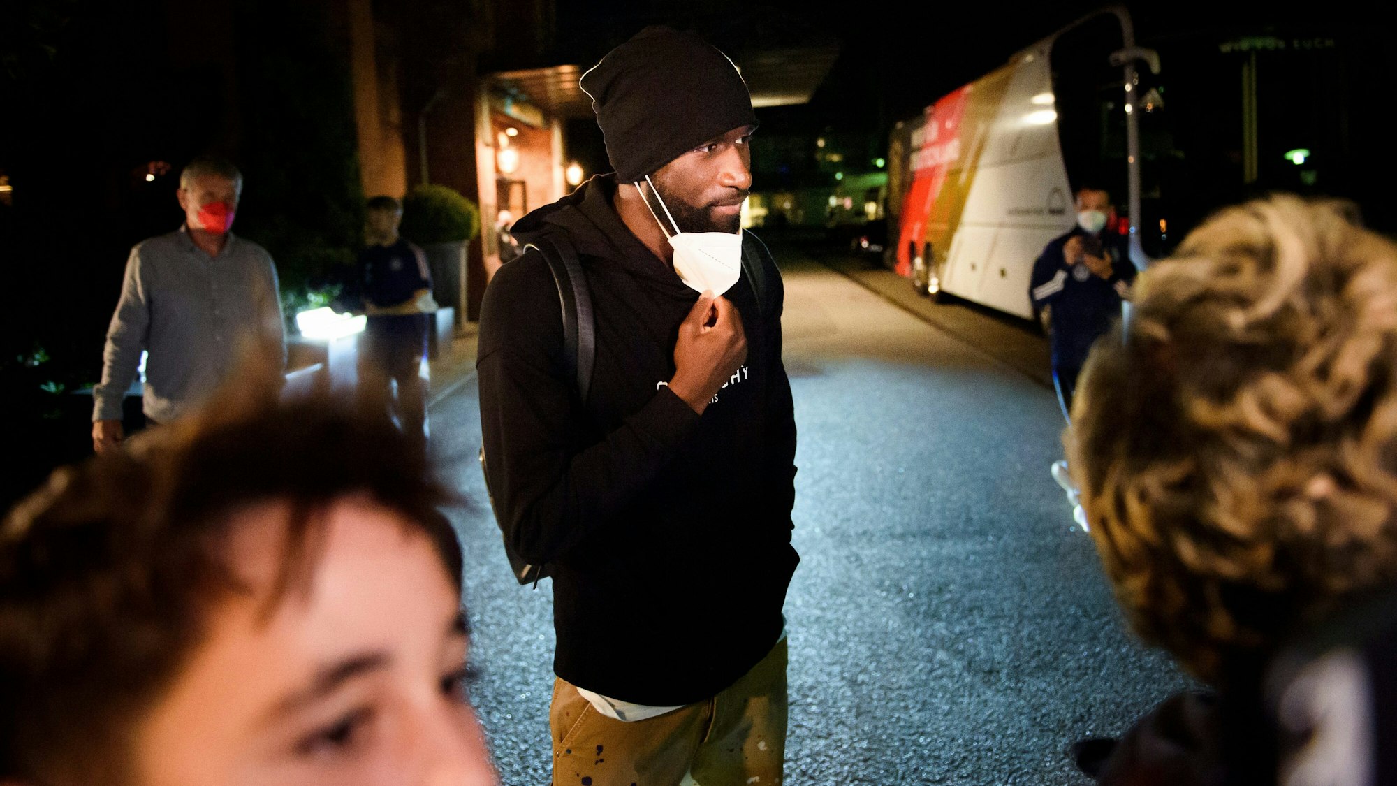 Antonio Rüdiger spricht vor dem Mannschaftshotel in Hamburg vor den Qualifikationsspielen zur Fußball-Weltmeisterschaft mit Fans an einer Absperrung.