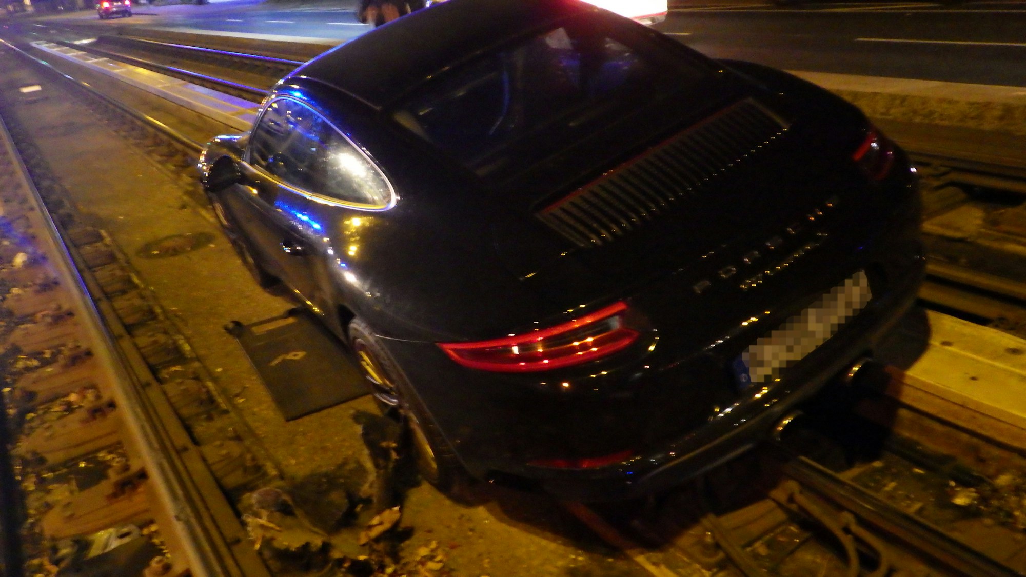 Der Porsche steht mit zwei Rädern im tiefer gelegenen Gleisbett.