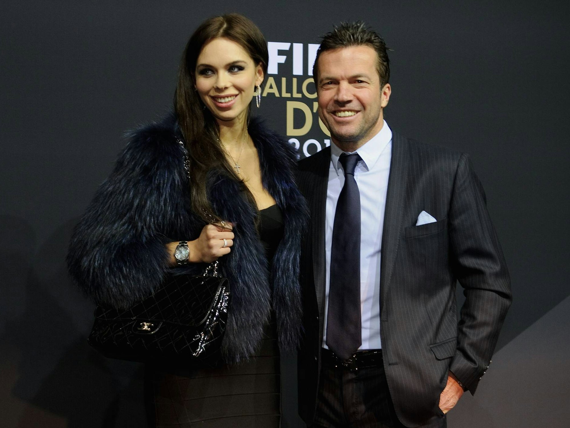 Lothar Matthäus mit Frau Liliana Matthäus posieren vor einer schwarzen Wand auf einer Preisverleihung.