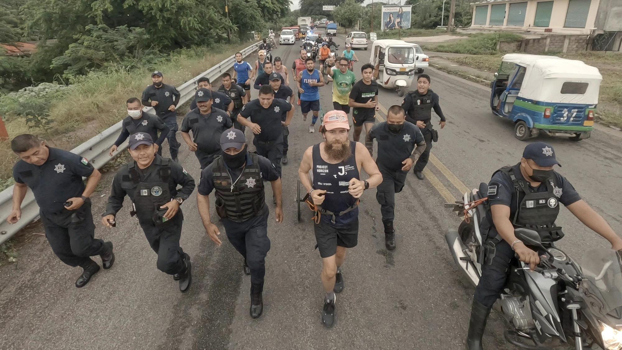 Jonas Deichmann (rosa Kappe) läuft am 02.09.2021 durch Mexiko und wird von einer Polizeieskorte begleitet.