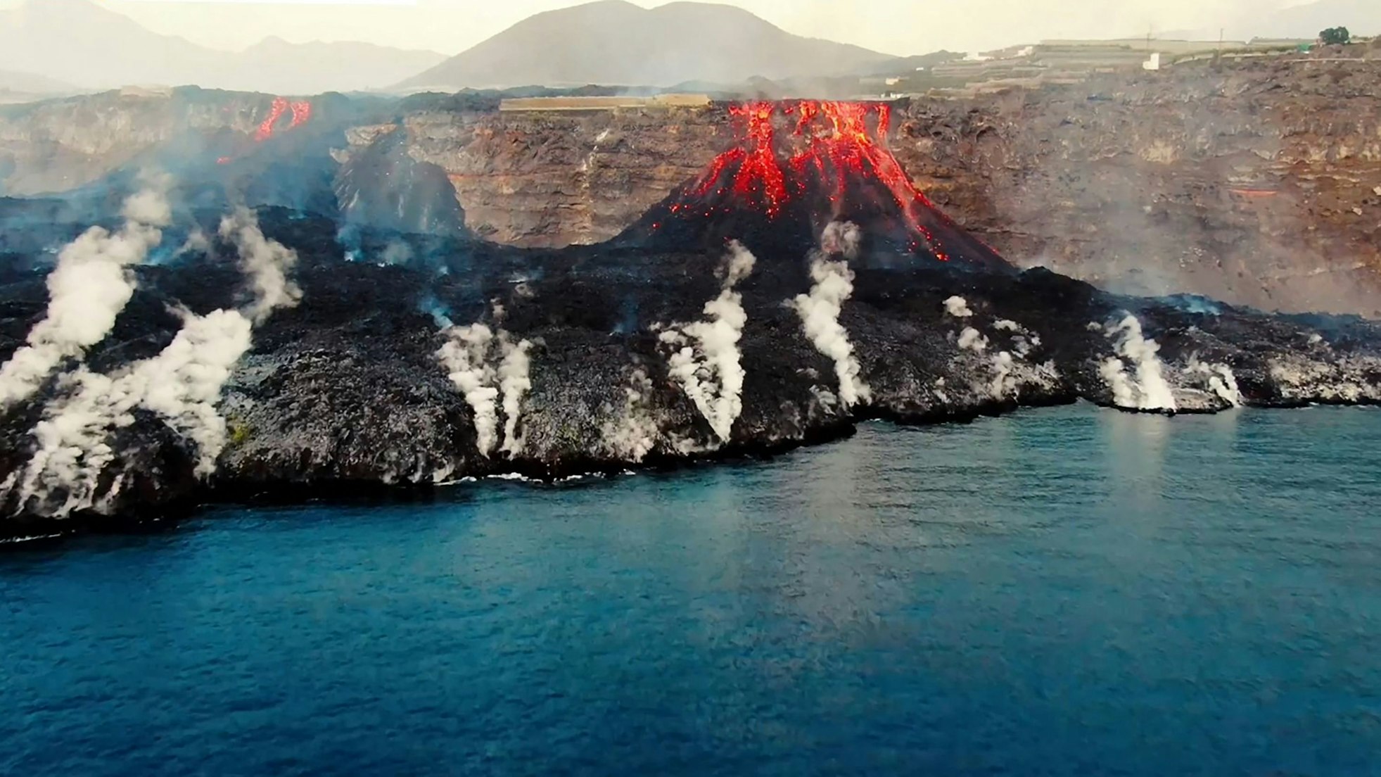 Im September 2021 ist auf La Palma ein bis dahin lange inaktiver Vulkan ausgebrochen – die Folgen davon sind noch immer spürbar. Das Foto (aufgenommen am 4. Oktober) zeigt, wie Lava an der Küste ins Meer stürzt.