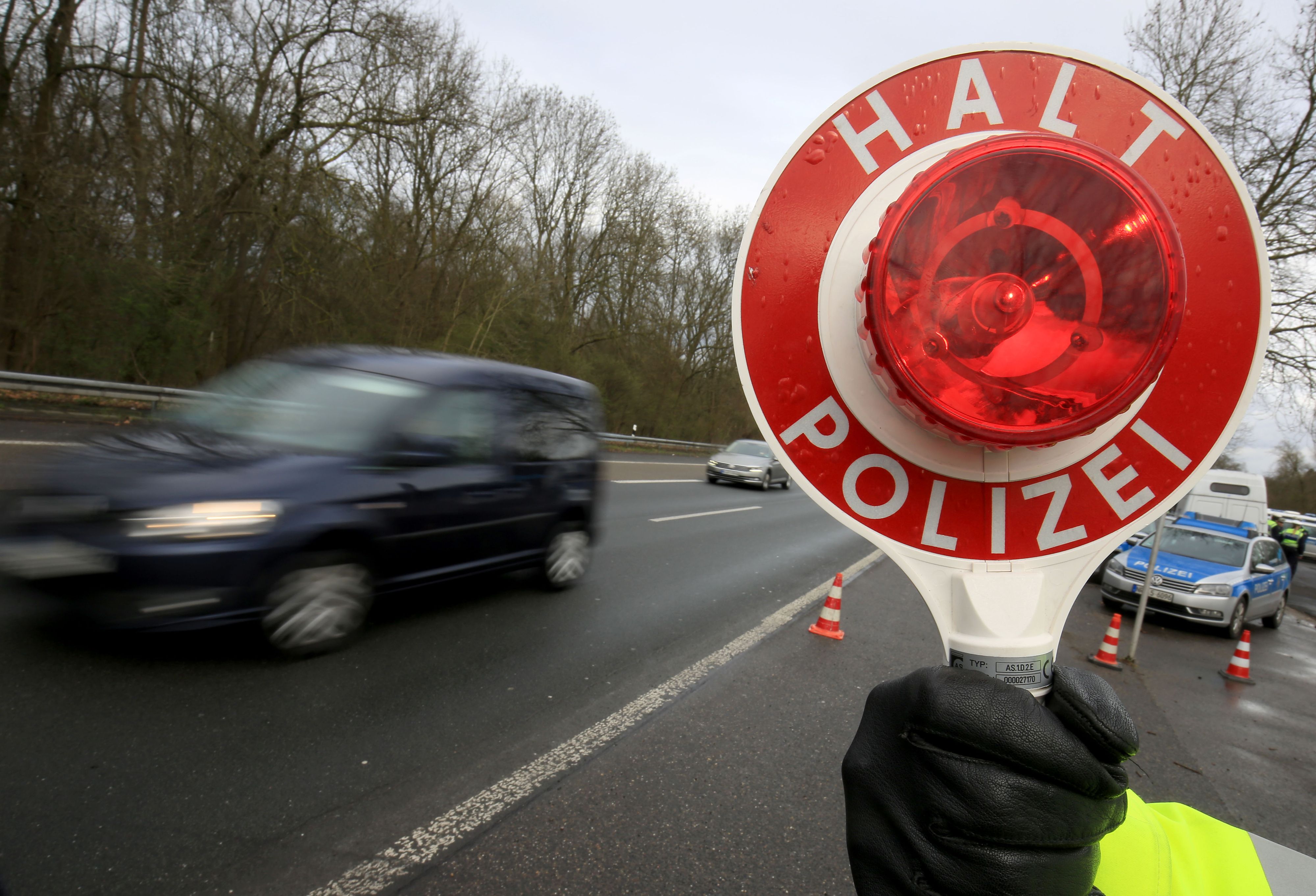 Ein Polizist winkt am 21.03.2017 auf der Autobahn 555 bei Köln (Nordrhein-Westfalen) Fahrzeuge zur Kontrolle raus.